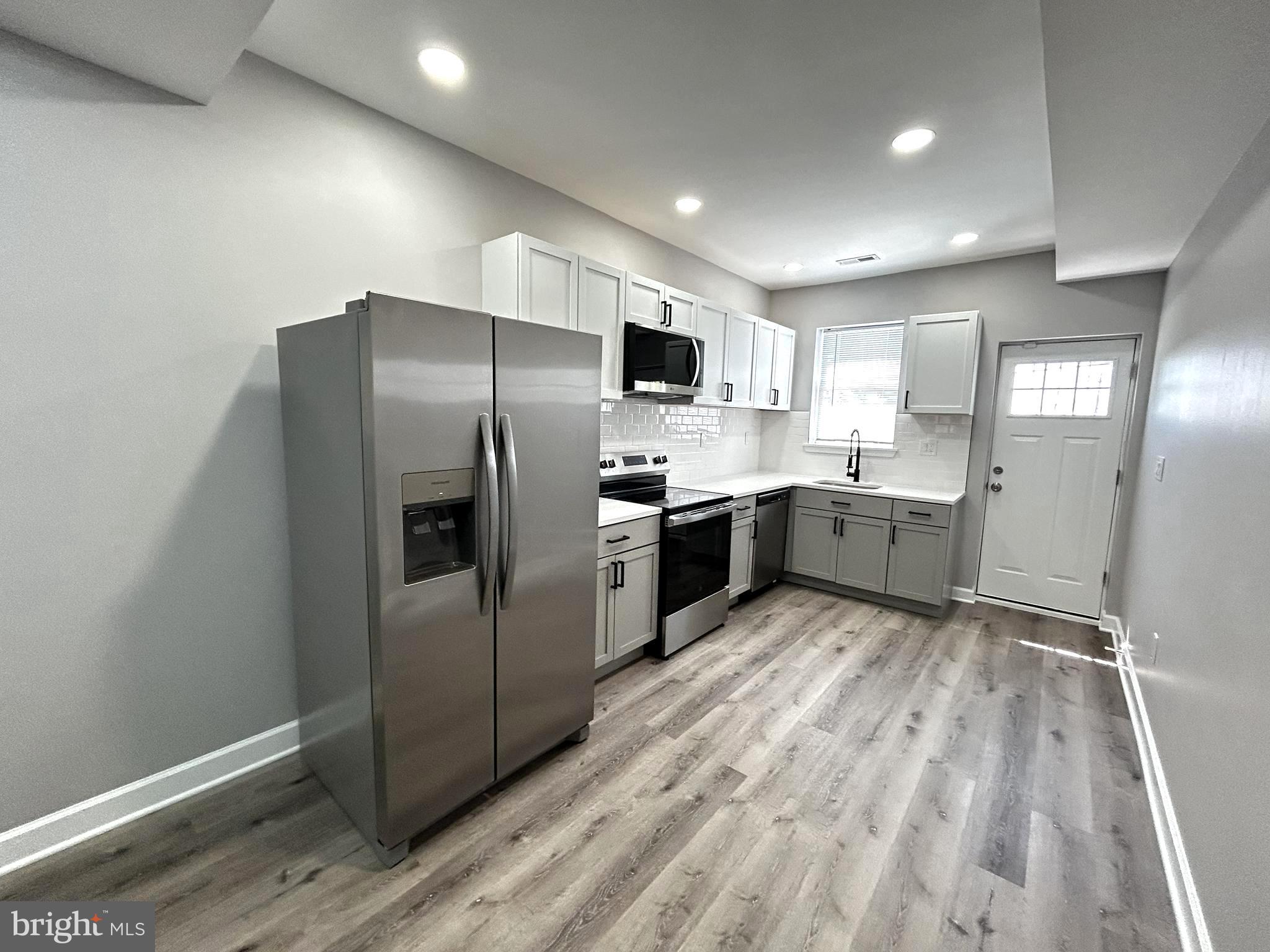 2815 East Chase Street Baltimore, MD 21213 - Photo 8 of 40 a kitchen with stainless steel appliances granite countertop a refrigerator and a sink
