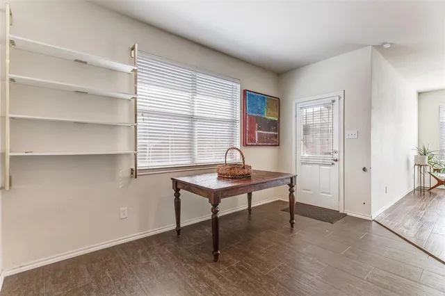 a view of a workspace with wooden floor and a window