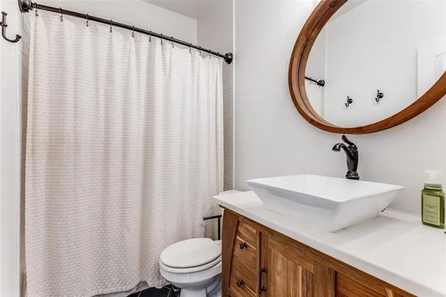 a bathroom with a sink a toilet and shower curtain