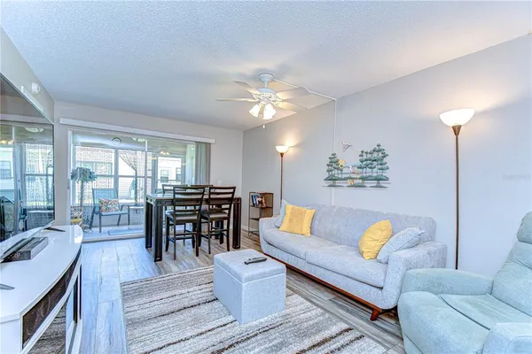 a living room with furniture and a dining table with large kitchen view