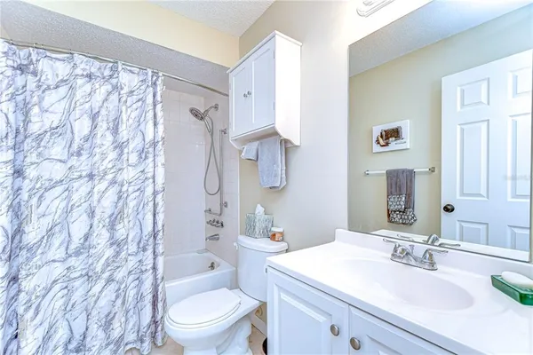 a bathroom with a sink a toilet and shower curtain