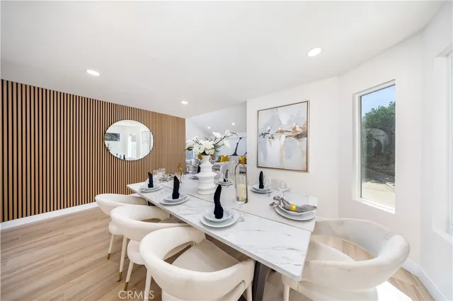 a dining room with wooden floor and large window