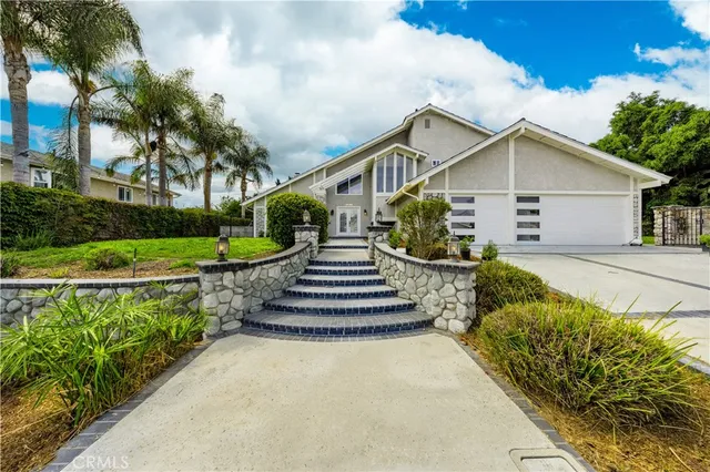 a front view of a house with a yard and potted plants