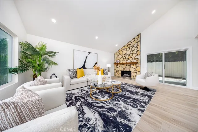 a living room with furniture large window and a fireplace