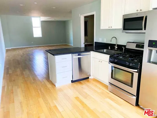 a kitchen with stainless steel appliances granite countertop a stove a sink and a microwave