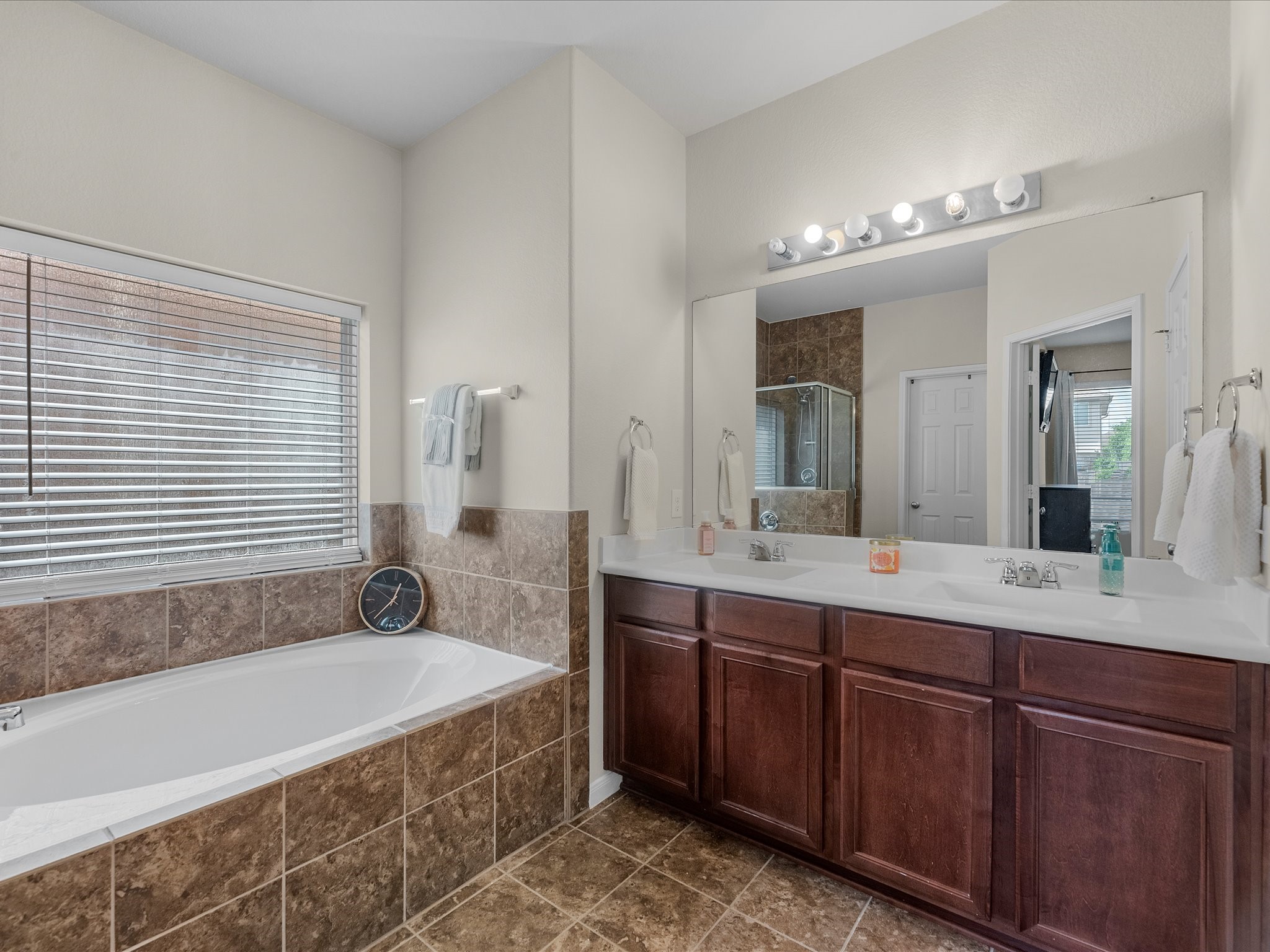 21554 Rainfall Park Drive Spring, TX 77388 - Photo 15 of 33 Primary bathroom features a spacious layout with a large soaking tub, dual sinks with a wide mirror.