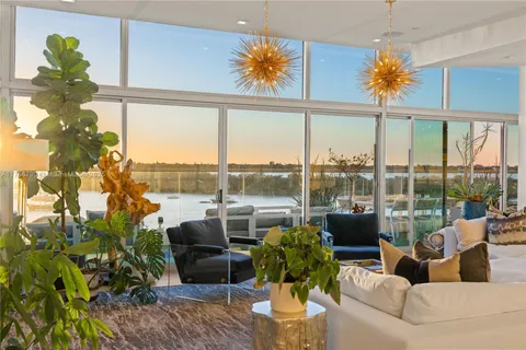a living room with patio furniture and a potted plant