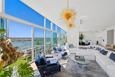 a living room with furniture potted plant and a chandelier