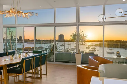 a view of a living room with furniture and floor to ceiling window