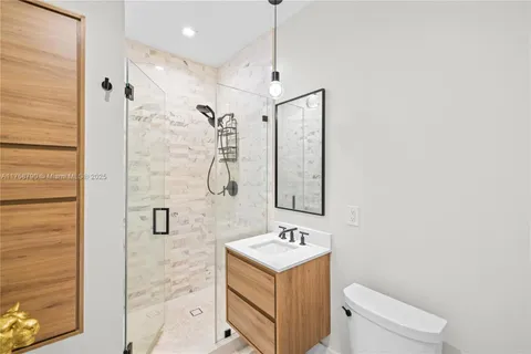 a bathroom with a sink vanity mirror and toilet