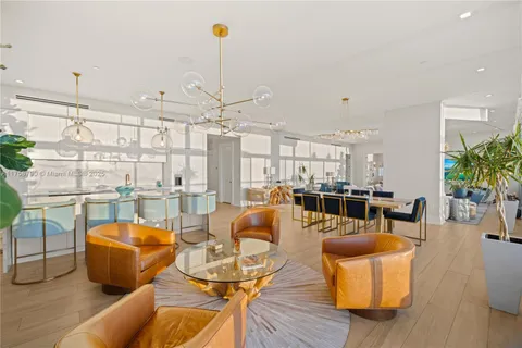 a living room with furniture kitchen view and large windows