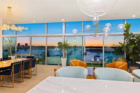 a living room with furniture a rug and a floor to ceiling window