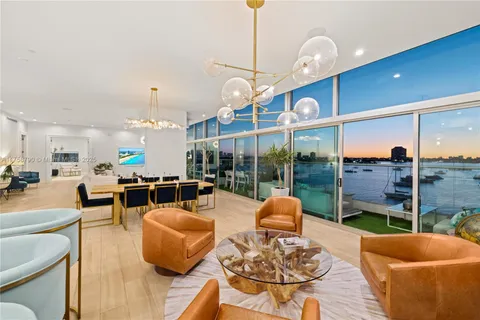 a living room with furniture kitchen view and a large window