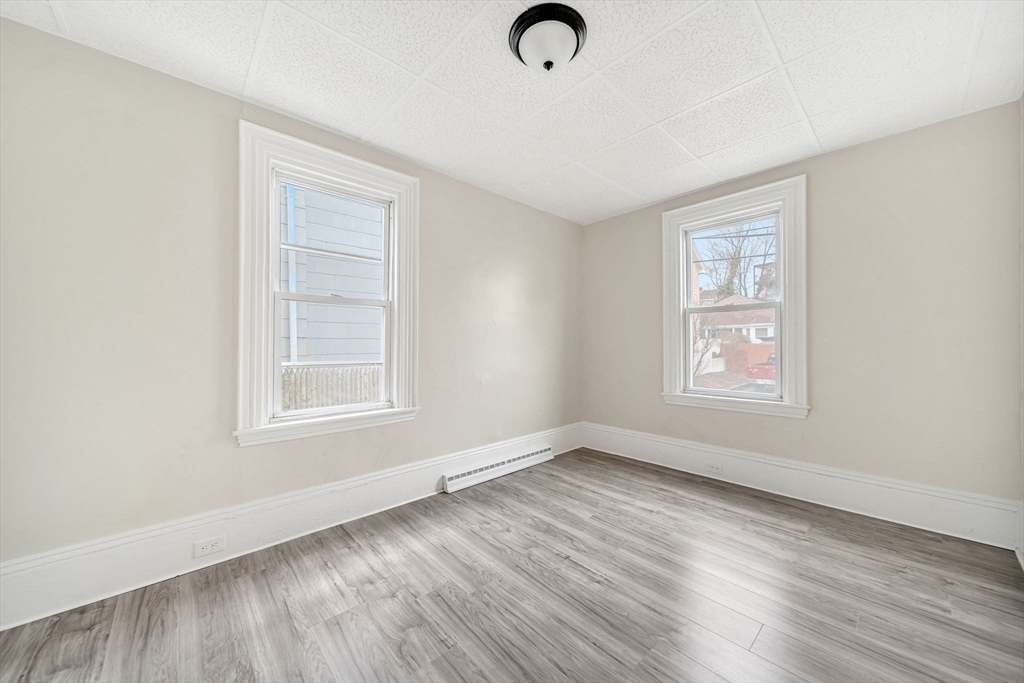20 Autumn Street Somerville, MA 02145 - Photo 12 of 34 an empty room with wooden floor cabinet and windows