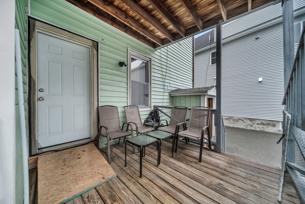 20 Autumn Street Somerville, MA 02145 - Photo 16 of 34 a view of a patio with table and chairs with wooden floor and fence