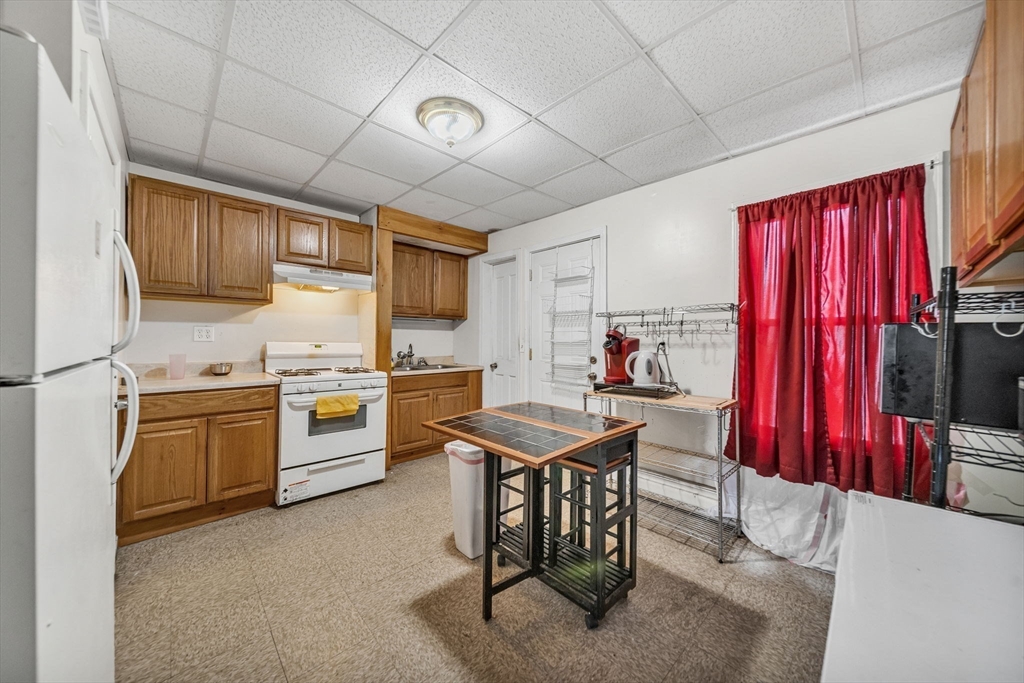 20 Autumn Street Somerville, MA 02145 - Photo 17 of 34 a kitchen with stainless steel appliances kitchen island granite countertop a table chairs sink and cabinets