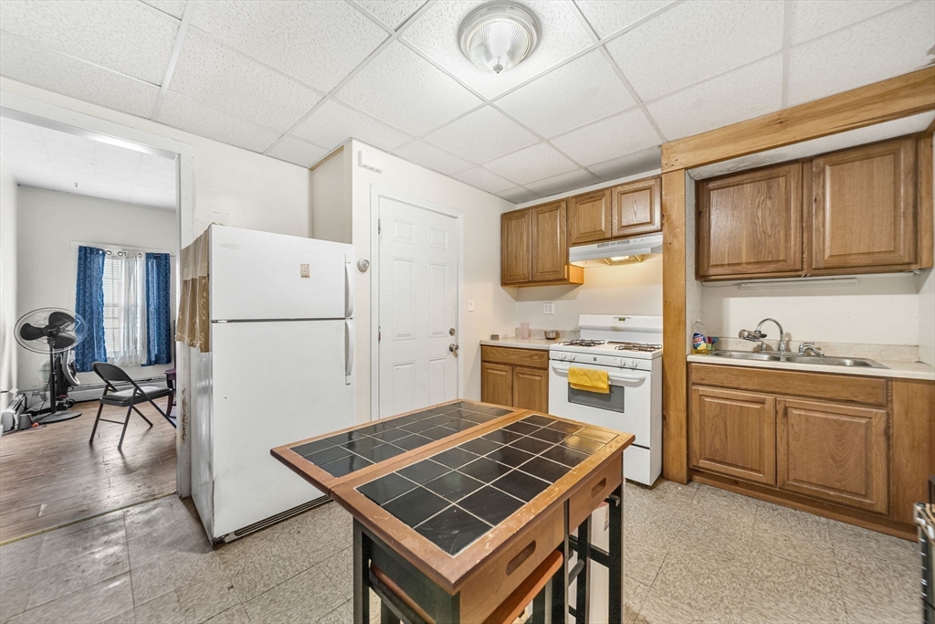 20 Autumn Street Somerville, MA 02145 - Photo 18 of 34 a kitchen with a stove a sink and a refrigerator