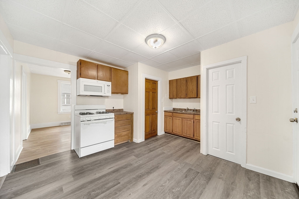 20 Autumn Street Somerville, MA 02145 - Photo 7 of 34 a kitchen with stainless steel appliances a refrigerator and a stove top oven