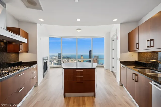 a kitchen with stainless steel appliances granite countertop a sink a stove and a refrigerator