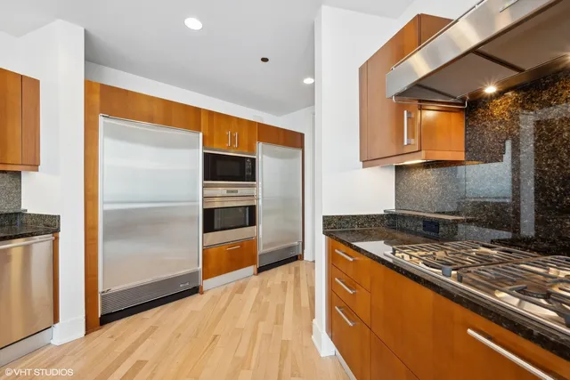 a kitchen with stainless steel appliances granite countertop a stove a sink and a refrigerator