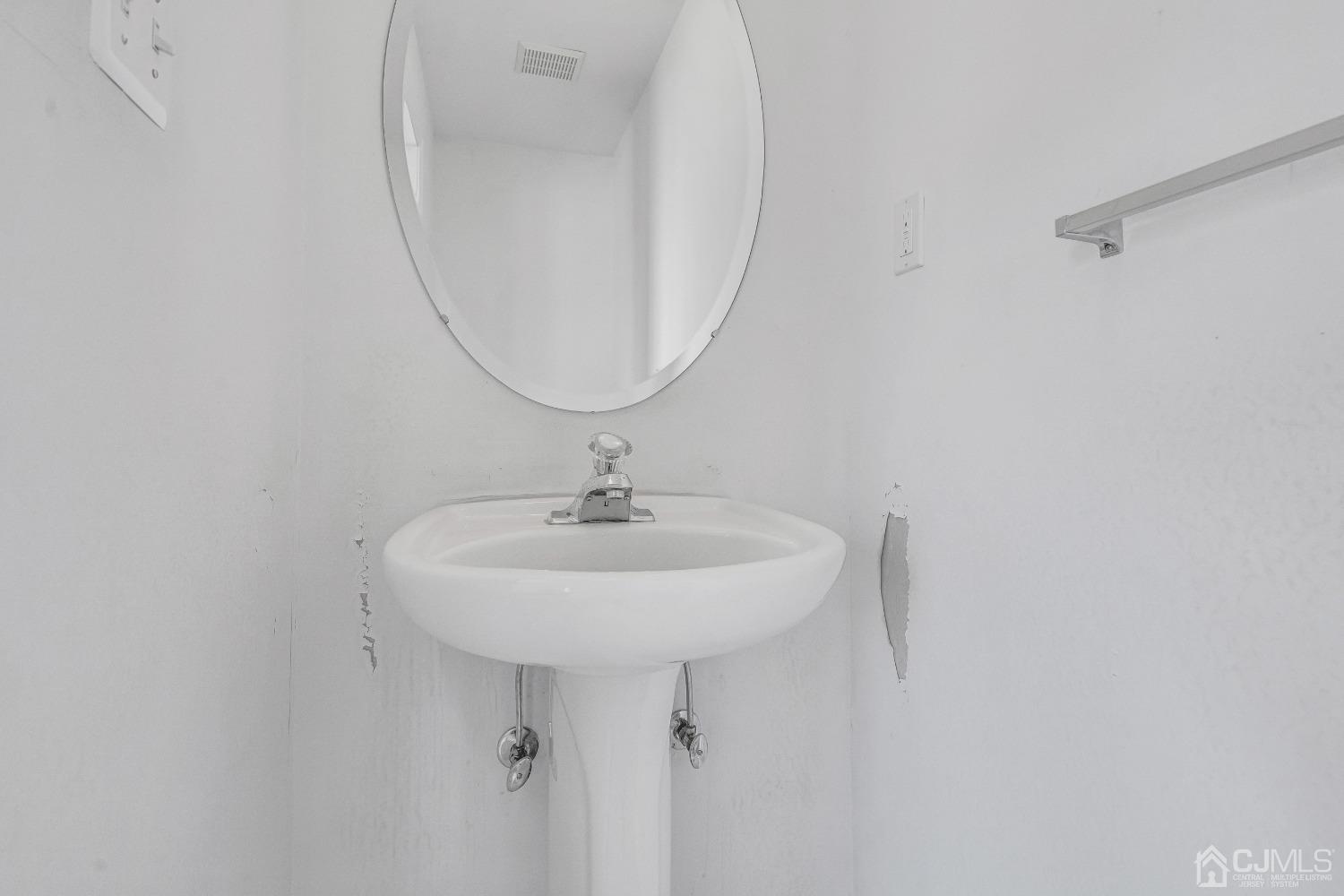 8 Fitzgerald Place Old Bridge, NJ 08857 - Photo 4 of 30 a bathroom with a sink a mirror and a light fixture