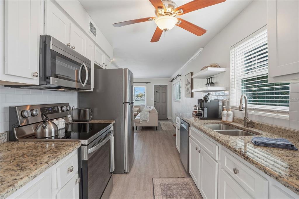 2605 Bay Boulevard Indian Rocks Beach, FL 33785 - Photo 32 of 82 a kitchen with stainless steel appliances granite countertop a sink stove and cabinets