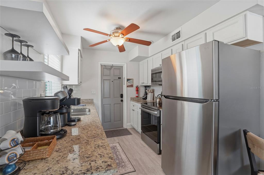 2605 Bay Boulevard Indian Rocks Beach, FL 33785 - Photo 34 of 82 a kitchen with stainless steel appliances a refrigerator and a stove top oven