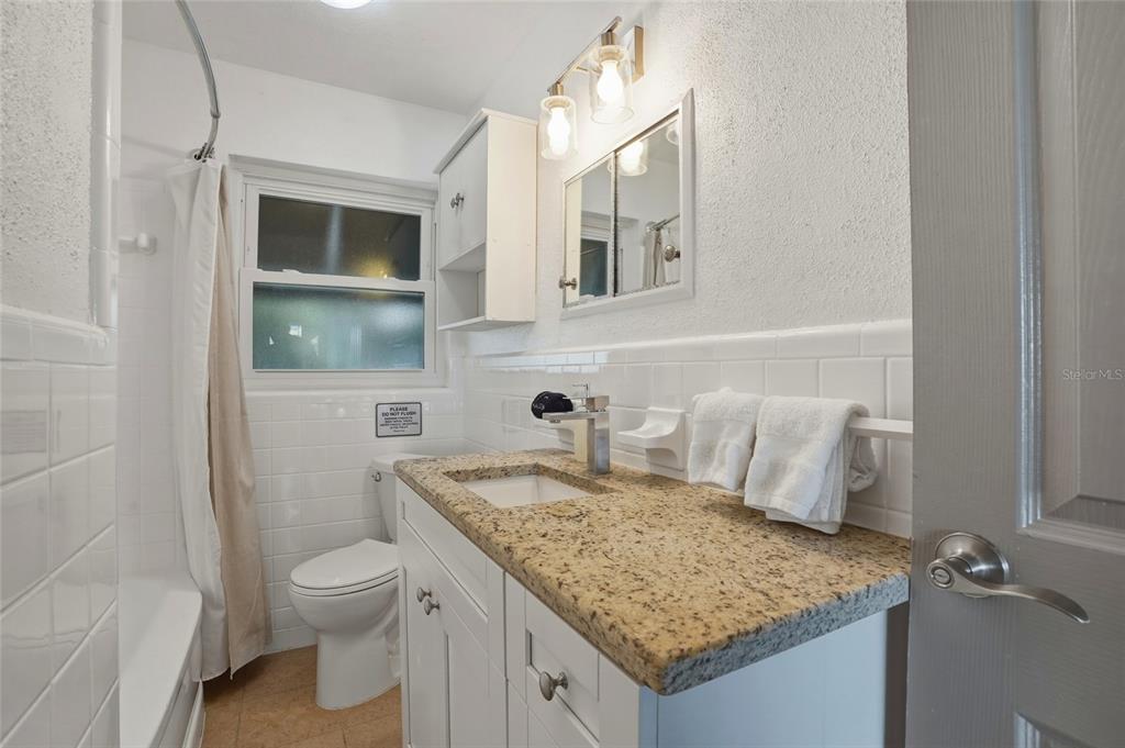 2605 Bay Boulevard Indian Rocks Beach, FL 33785 - Photo 42 of 82 a bathroom with a granite countertop sink and a mirror