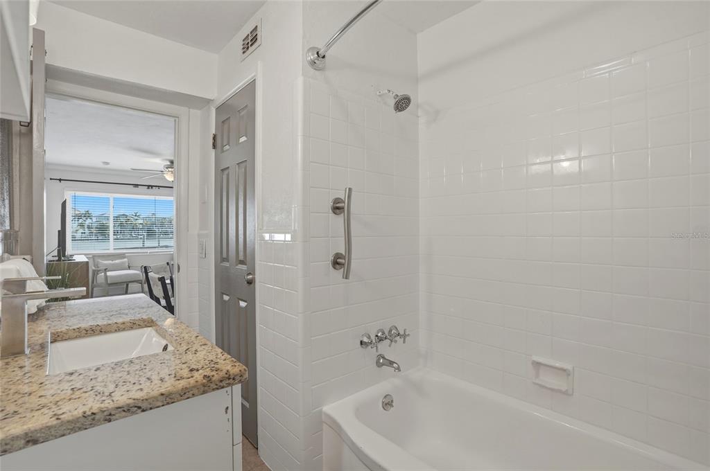 2605 Bay Boulevard Indian Rocks Beach, FL 33785 - Photo 43 of 82 a bathroom with a granite countertop tub sink and mirror