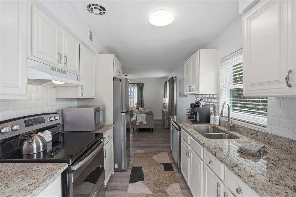 2605 Bay Boulevard Indian Rocks Beach, FL 33785 - Photo 53 of 82 a kitchen with stainless steel appliances granite countertop a sink stove and refrigerator