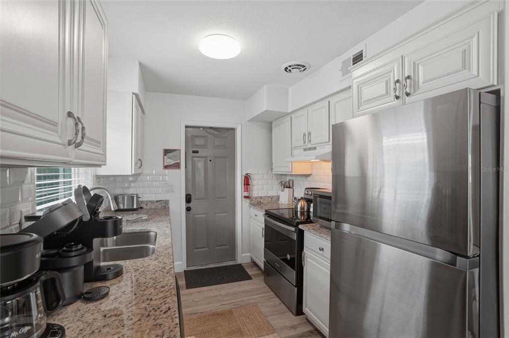 2605 Bay Boulevard Indian Rocks Beach, FL 33785 - Photo 54 of 82 a kitchen with stainless steel appliances a refrigerator a stove a sink and dishwasher