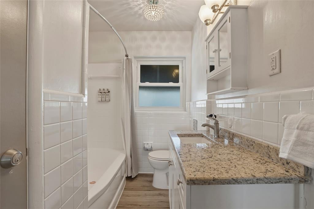 2605 Bay Boulevard Indian Rocks Beach, FL 33785 - Photo 66 of 82 a bathroom with a granite countertop sink a toilet and bathtub