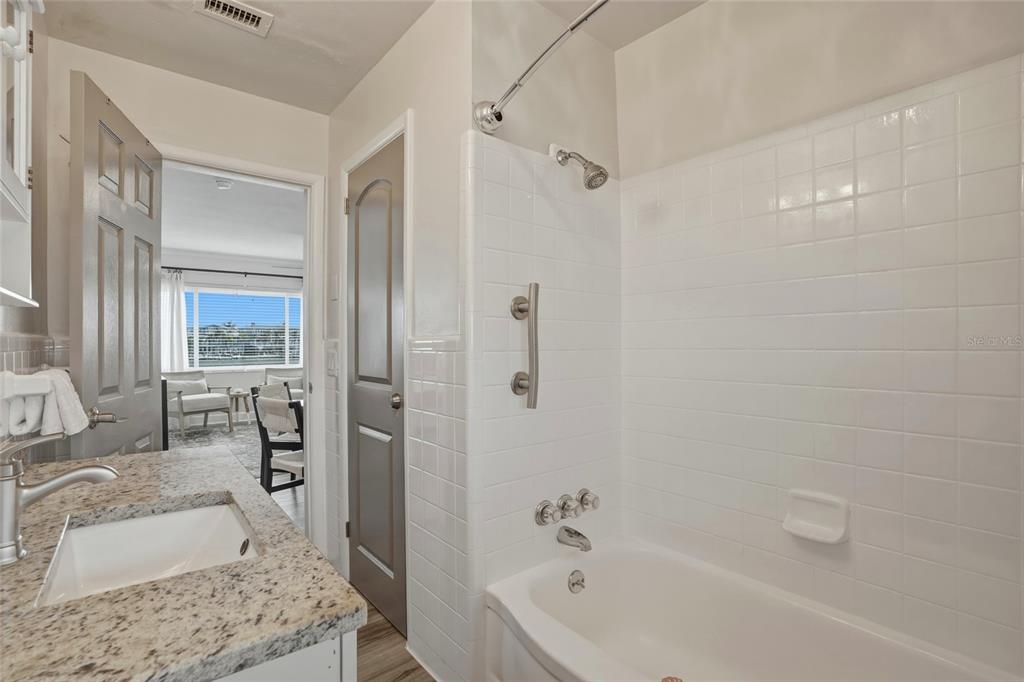2605 Bay Boulevard Indian Rocks Beach, FL 33785 - Photo 67 of 82 a bathroom with a granite countertop tub sink a mirror and shower