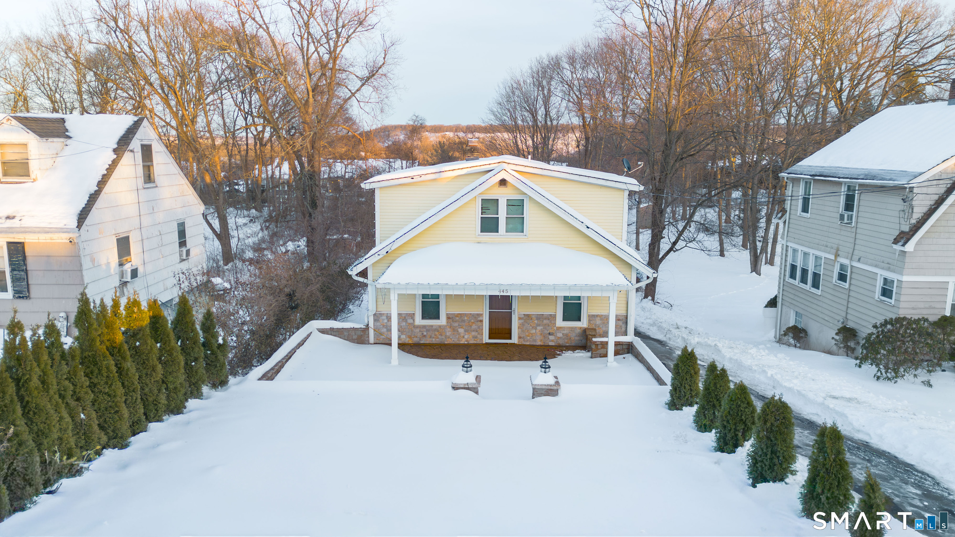 a view of a house with a yard covered with snow in front of house