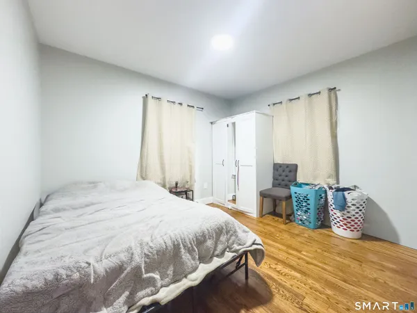 a spacious bedroom with a bed and wooden floor