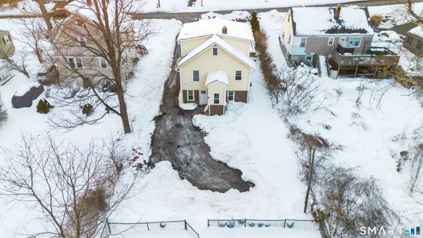 a view of a white house with a snow on the road