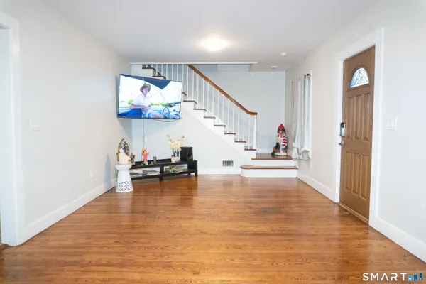 a view of a livingroom with furniture staircase and hallway