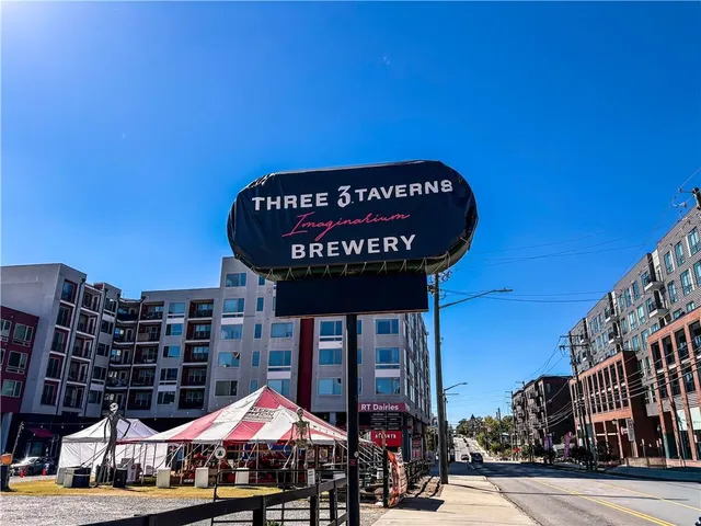 a sign board with buildings in the background