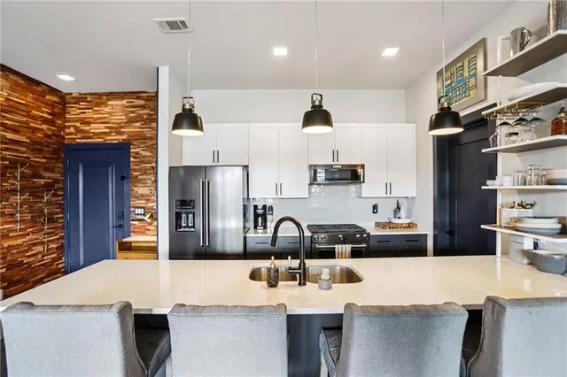 a kitchen with kitchen island a sink appliances and cabinets