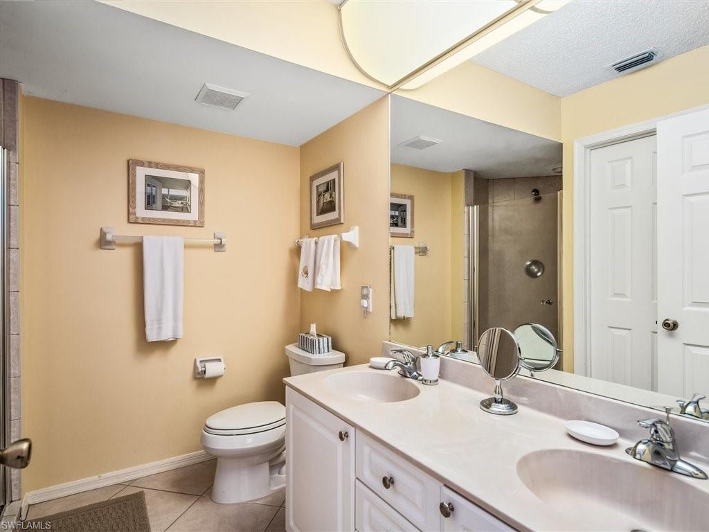 149 Wading Bird Circle, Unit I205 Naples, FL 34110 - Photo 11 of 27 a bathroom with a toilet sink and mirror