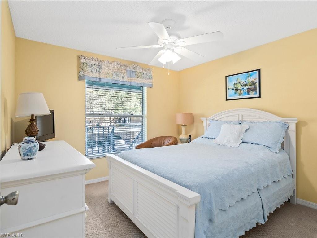 149 Wading Bird Circle, Unit I205 Naples, FL 34110 - Photo 13 of 27 a bedroom with a bed and a table