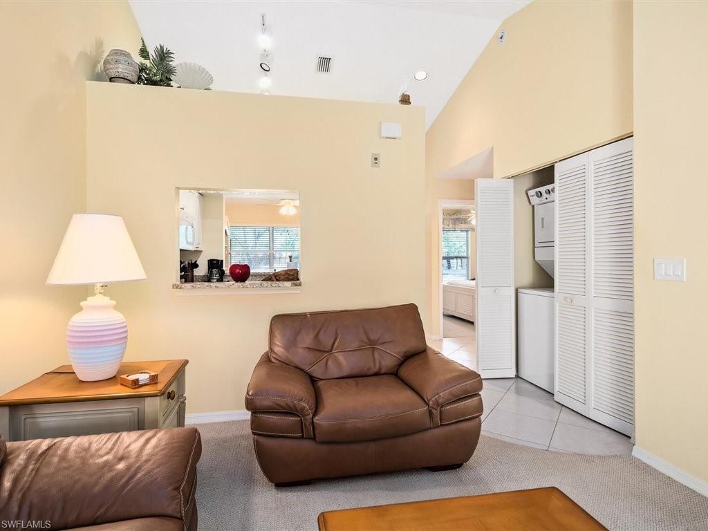 149 Wading Bird Circle, Unit I205 Naples, FL 34110 - Photo 5 of 27 a living room with furniture and a lamp