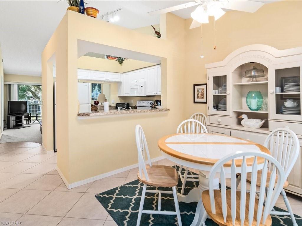 149 Wading Bird Circle, Unit I205 Naples, FL 34110 - Photo 8 of 27 a view of a dining room with furniture and a chandelier
