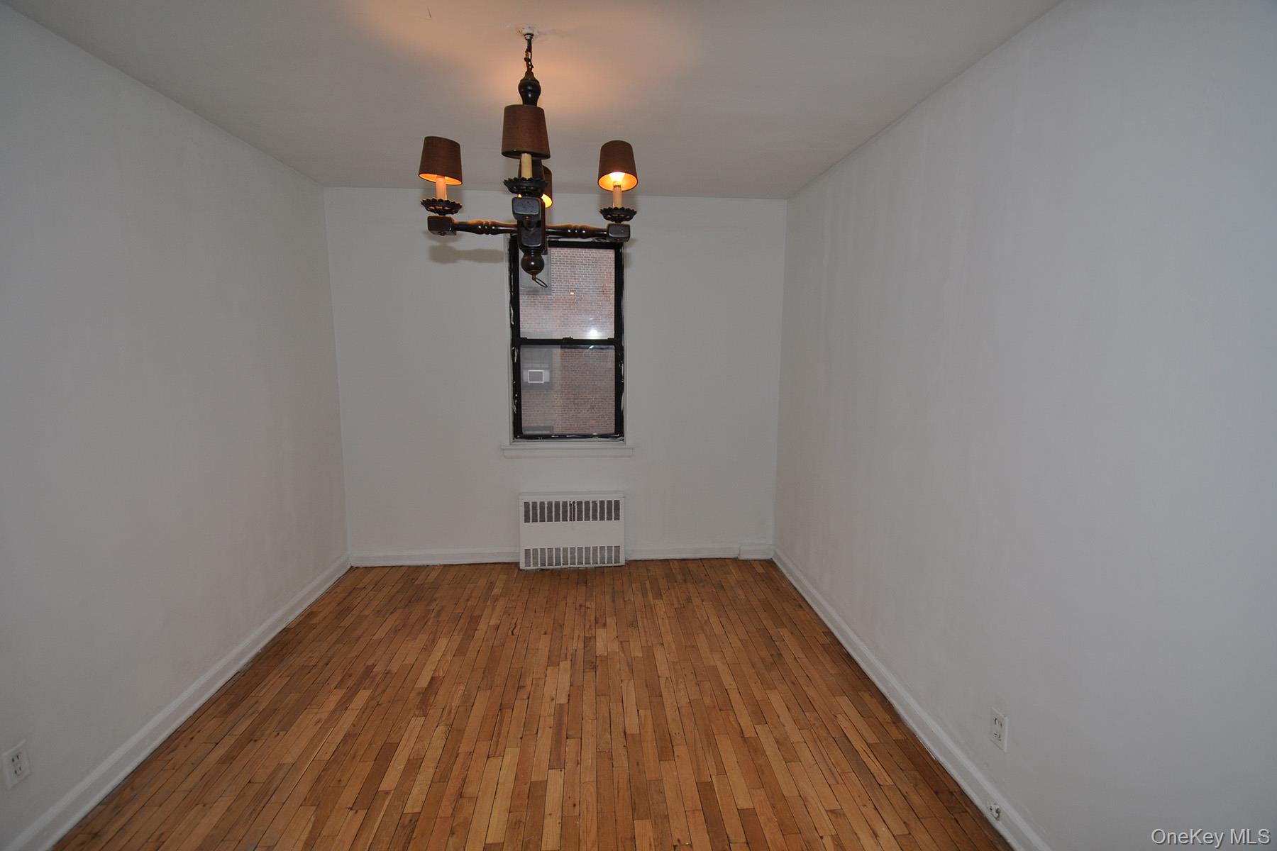142 Garth Road, Unit 1R Scarsdale, NY 10583 - Photo 8 of 12 a view of a room with wooden floor and fan