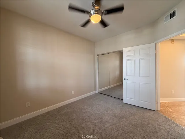an empty room with closet and windows