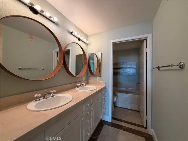 a bathroom with a double vanity sink and a mirror