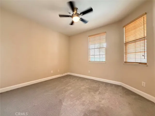 an empty room with windows and fan