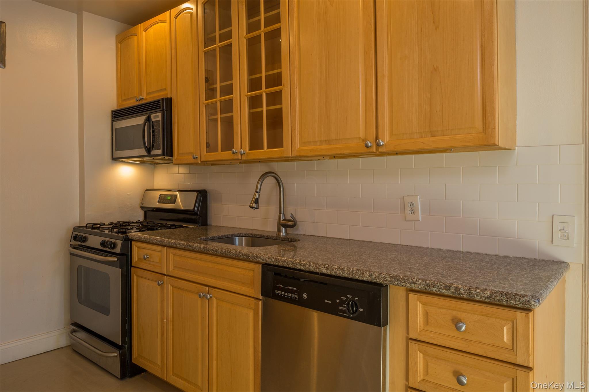 9 Alden Place, Unit G9 Bronxville, NY 10708 - Photo 9 of 11 a kitchen with stainless steel appliances granite countertop a sink stove and microwave