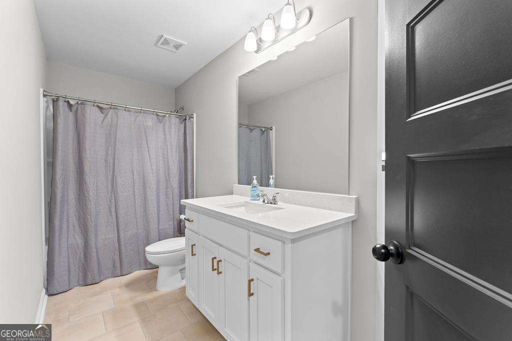 121 Cedar Pk Way Carrollton, GA 30117 - Photo 20 of 33 a bathroom with a double vanity sink a toilet and a mirror