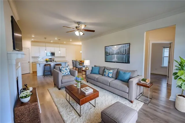 a living room with furniture kitchen view and a window